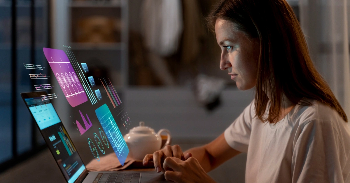A woman is focused on her laptop, surrounded by holographic data projections of AI Call Center Agents, including graphs and charts. A white teapot sits nearby on the table in the dimly lit room. VoiceDrop Ringless Voicemails