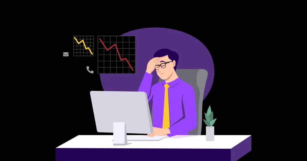 Illustration of a worried man in business attire sitting at a desk with a computer. Two charts with downward trends appear behind him, indicating financial loss or crisis, as he considers cold calling alternatives. A small plant sits on the desk. VoiceDrop Ringless Voicemails